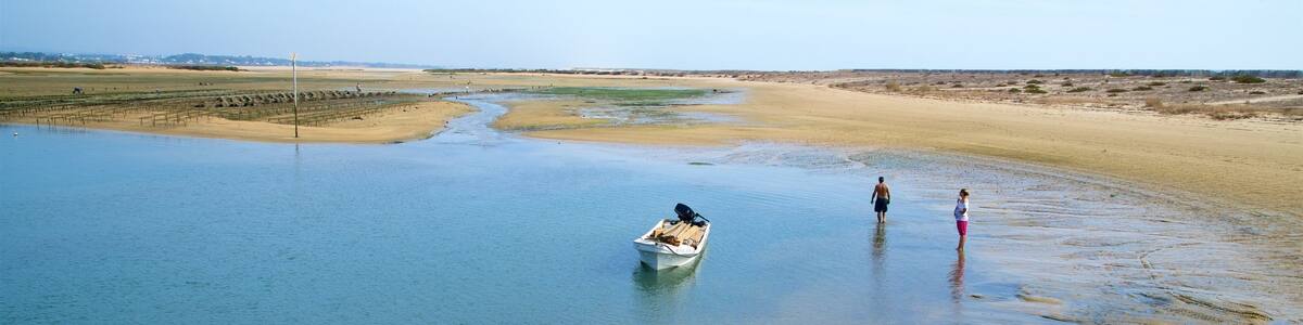 Fuzeta Beach showing a lake or waterhole and tranquil scenes as well as a couple