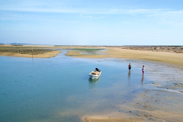 Fuzeta Beach das einen See oder Wasserstelle und ruhige Szenerie sowie Paar