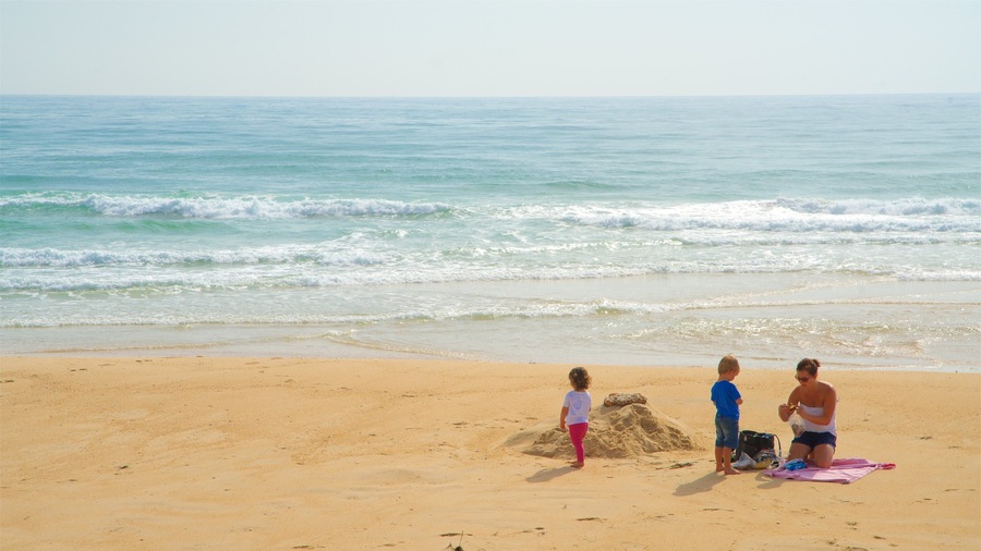 Fuzeta Beach featuring general coastal views and a sandy beach as well as a family