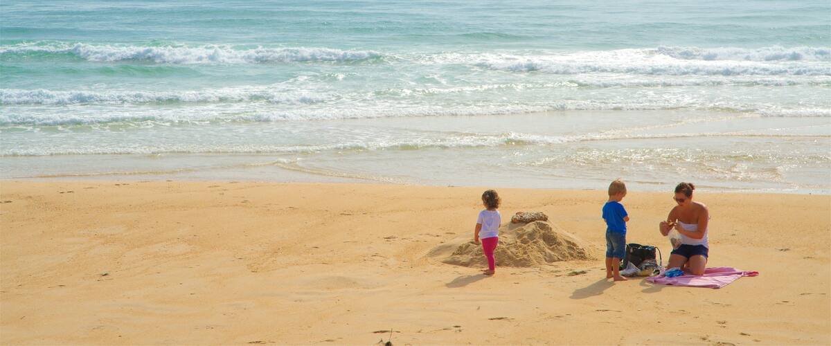A sandy beach with gentle waves and a clear sky.