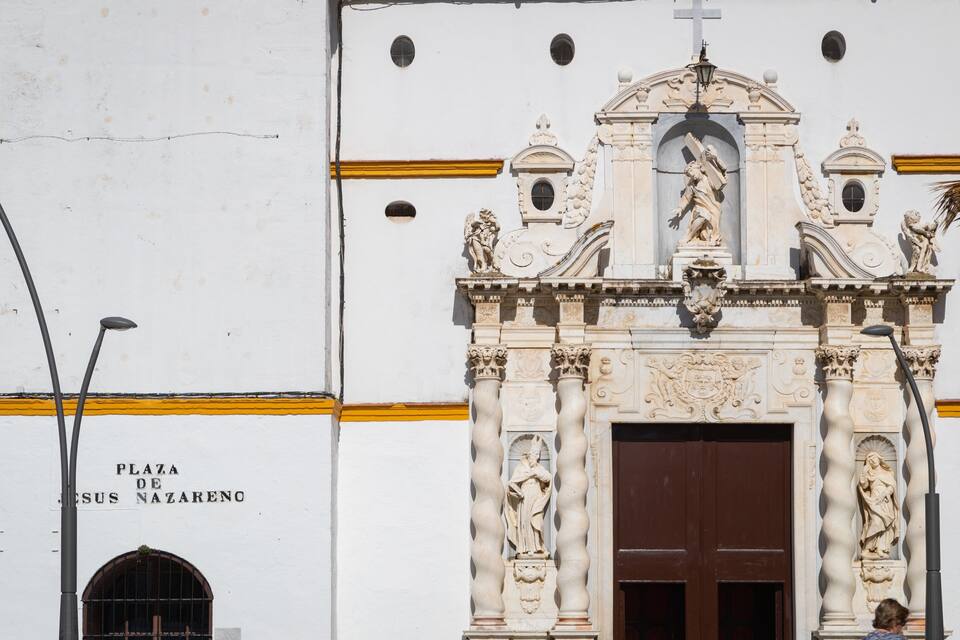 A white building with ornate carvings and a large brown door.