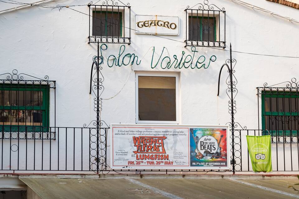 A white building with green shutters and a sign that reads "Salon Varlet."