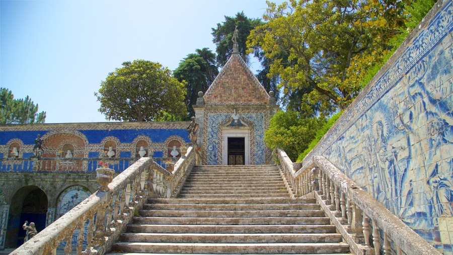 A staircase leading to a tiled building with a statue on top.