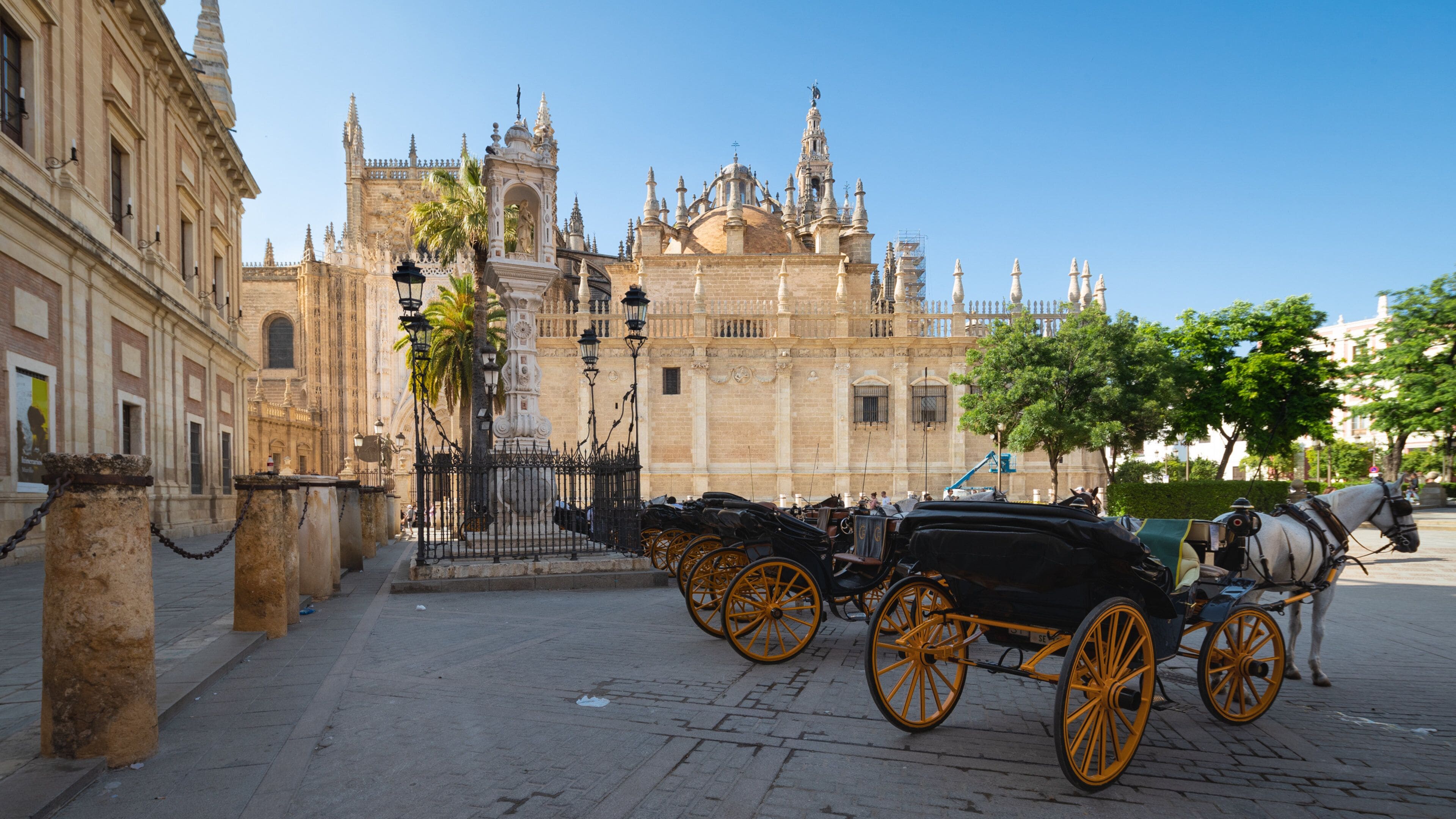 A historic building with ornate architecture and a horse-drawn carriage in front.