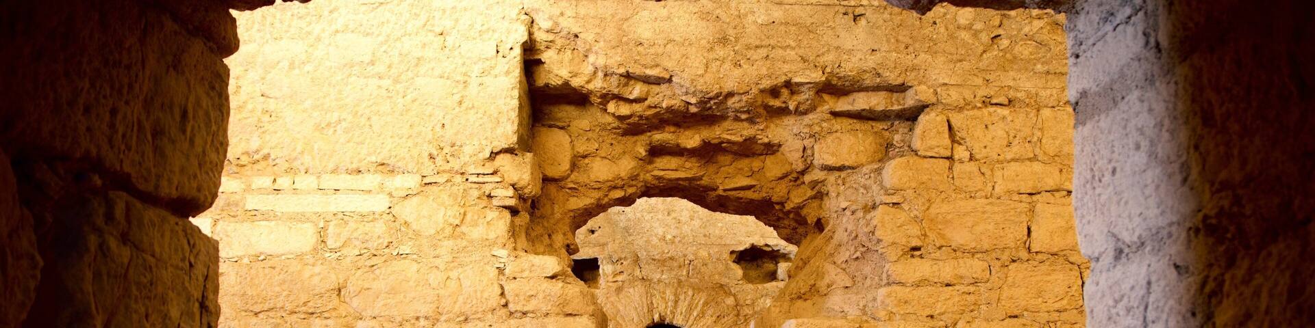 Una estructura de piedra antigua con un estrecho pasillo que conduce a una habitación pequeña.