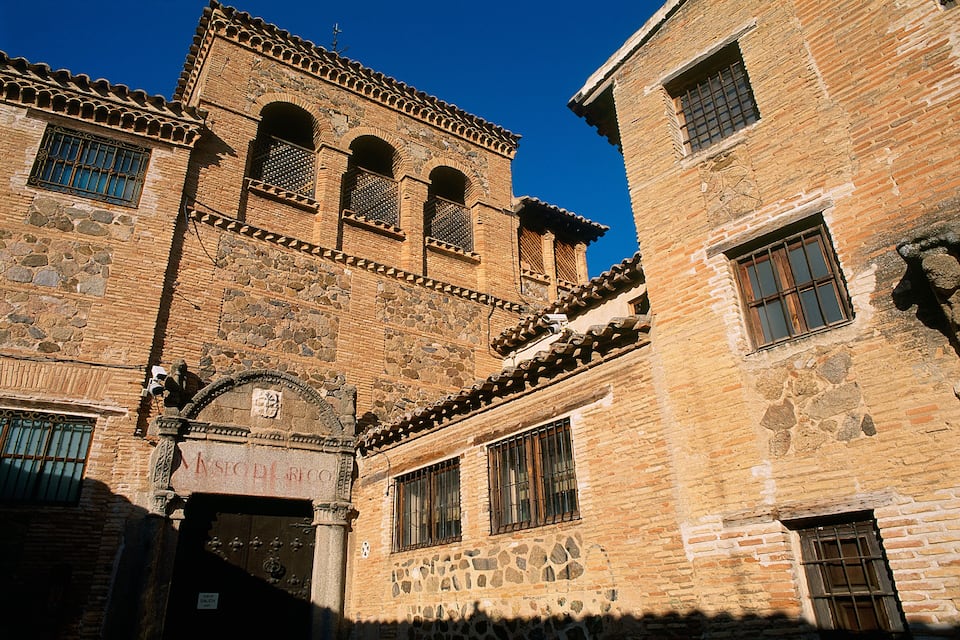 An old stone building with arched windows and a sign that reads "MASOVER BICICLIS."