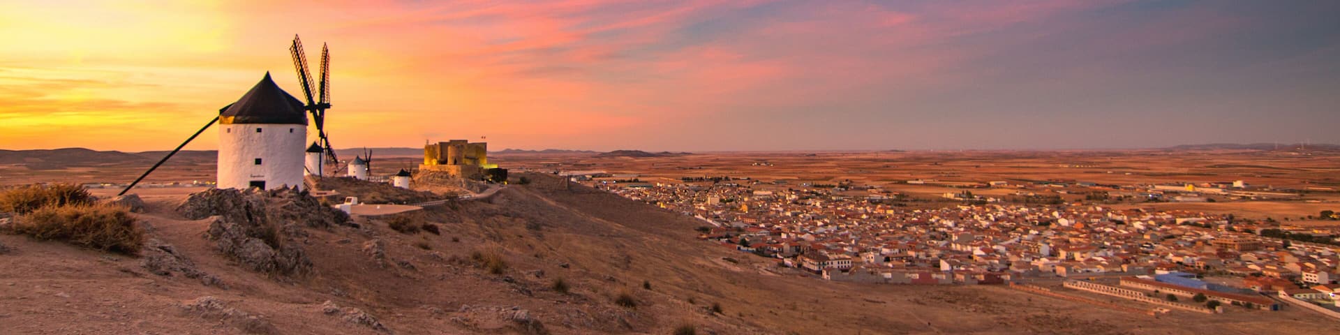 A windmill, a town, and a sunset.