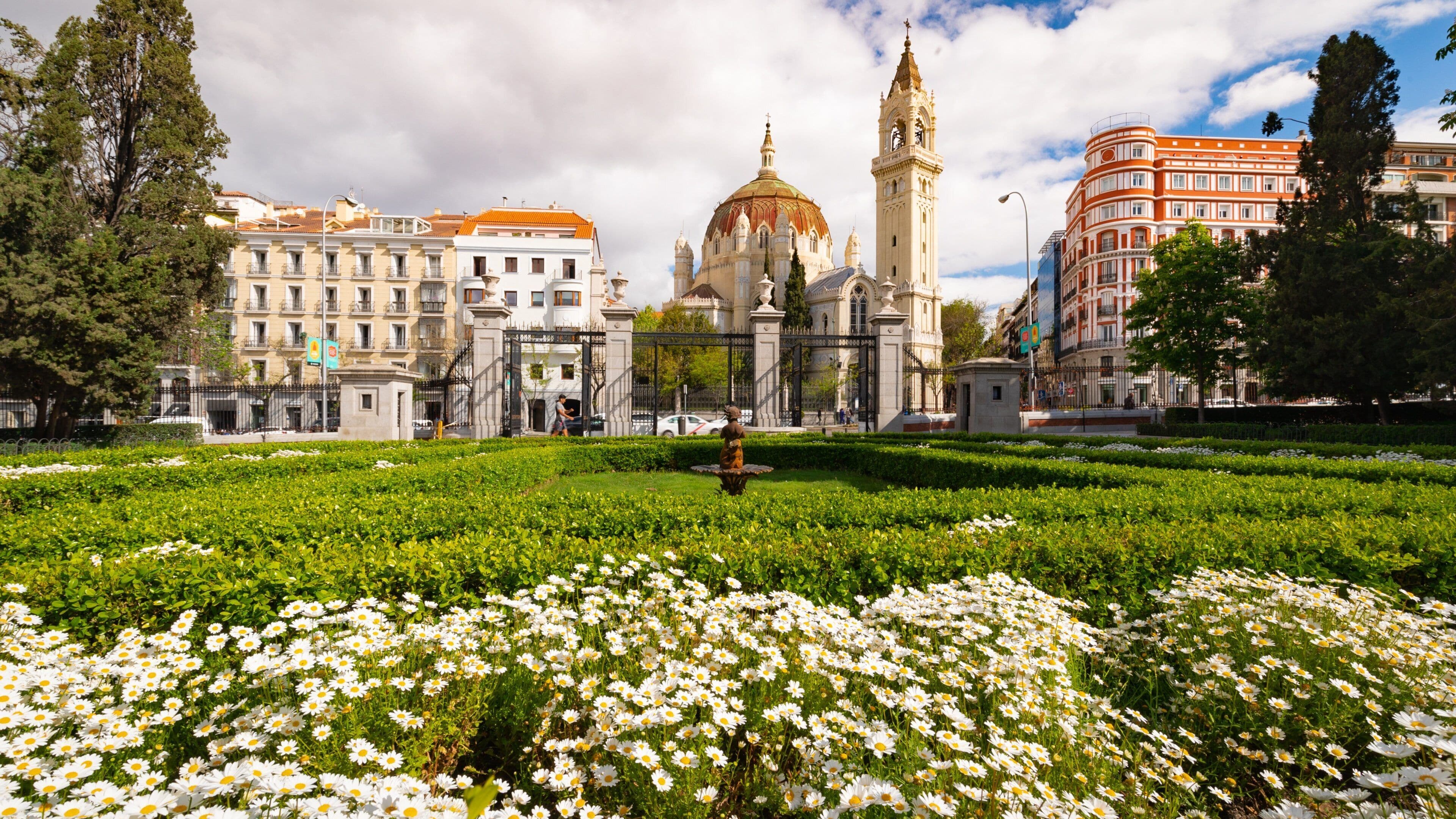 Church of San Manuel y San Benito which includes heritage architecture, flowers and a park
