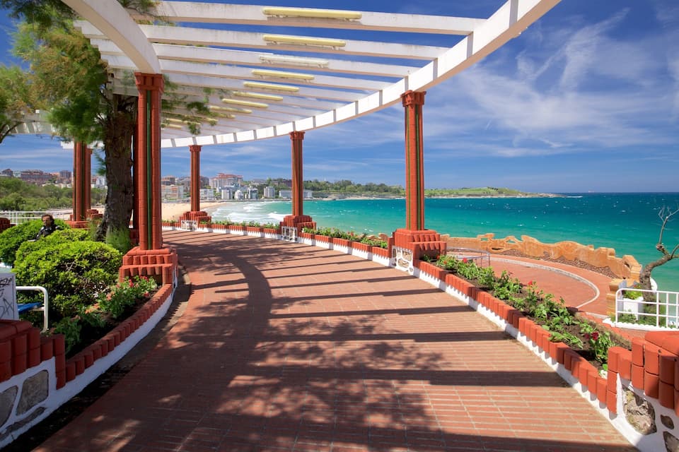 A coastal walkway with red brick flooring, white railings, and red columns.