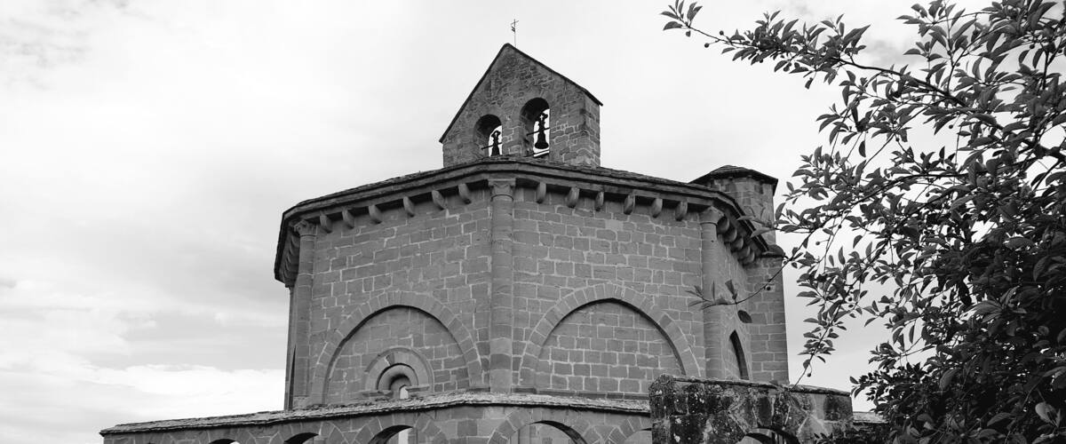 A historic stone building with a bell tower and arched windows.