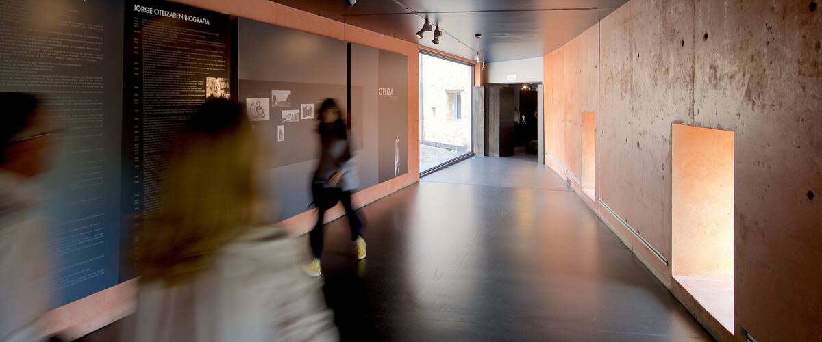 A modern interior space with informational displays and a concrete wall.