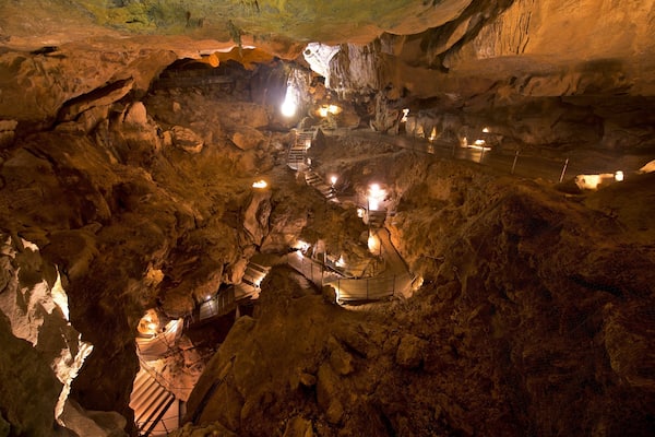 A cave with illuminated pathways and stalactites.