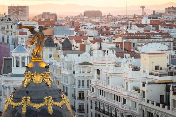 Eine Stadtansicht mit einem markanten Gebäude mit goldener Kuppel und einer Statue eines Engels.