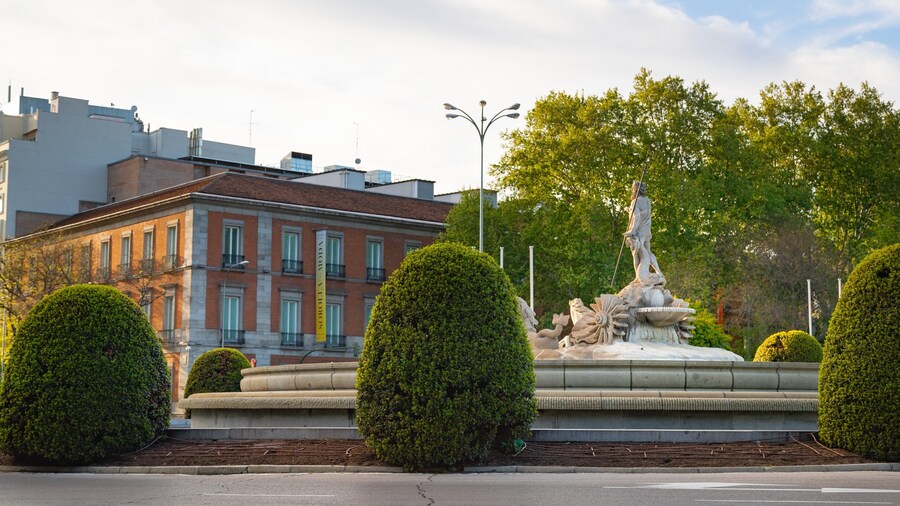 Fountain of Neptune featuring a garden and a statue or sculpture