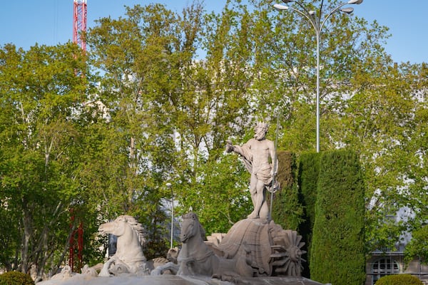 Fountain of Neptune featuring a statue or sculpture and a garden