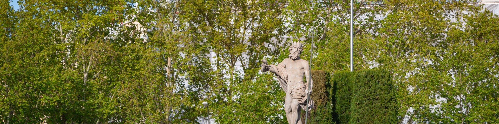 Fountain of Neptune featuring a statue or sculpture and a garden