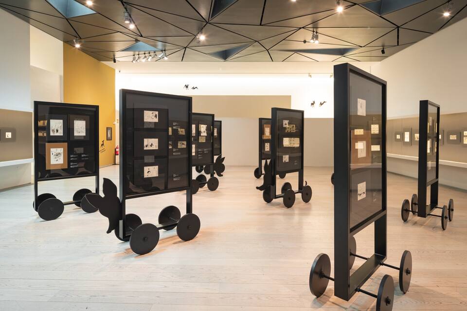 Eine Kunstgalerie mit Holzböden und Deckenleuchten.