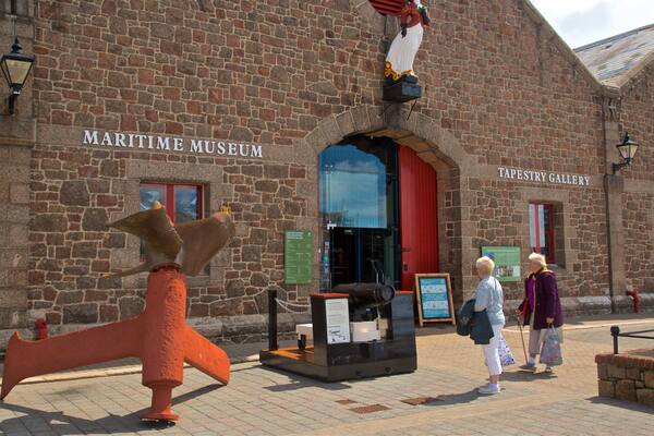 Das Maritime Museum und die Teppichgalerie mit einem großen Schiffsschwengel und einer Statue einer Person in einem roten Mantel.