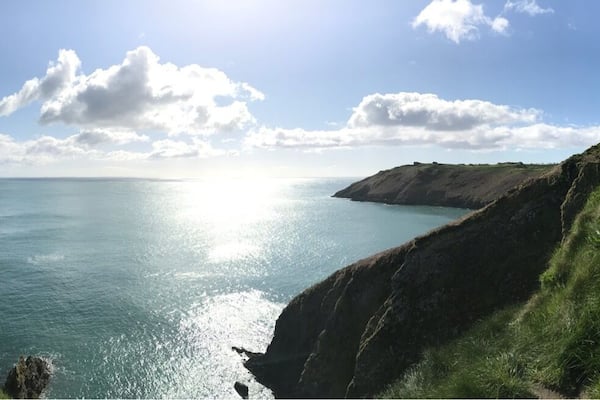 Eine Küstenlandschaft mit Klippen und freiem Blick auf das Meer.