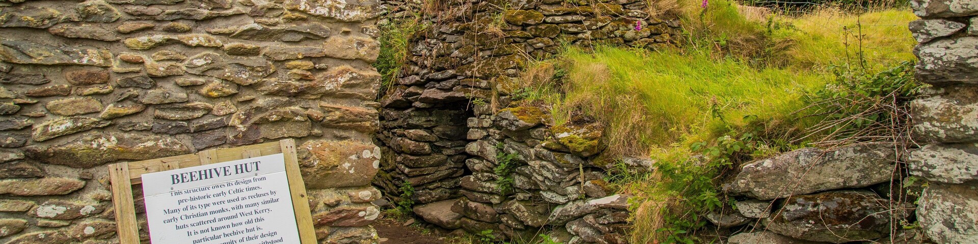 Uma cabana de pedra com uma placa que explica seu valor histórico.