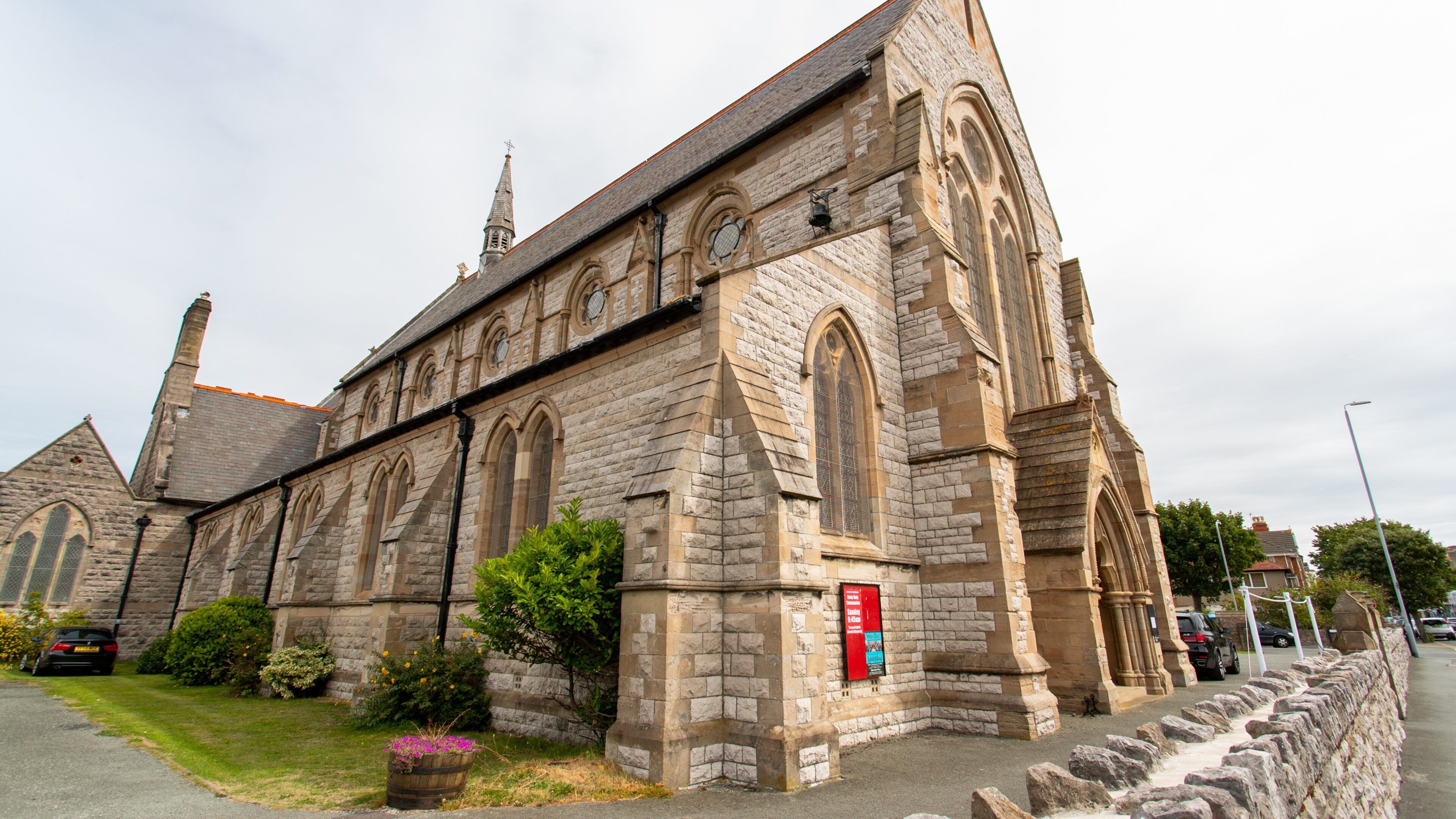 A historic stone church with arched windows and a tall steeple.