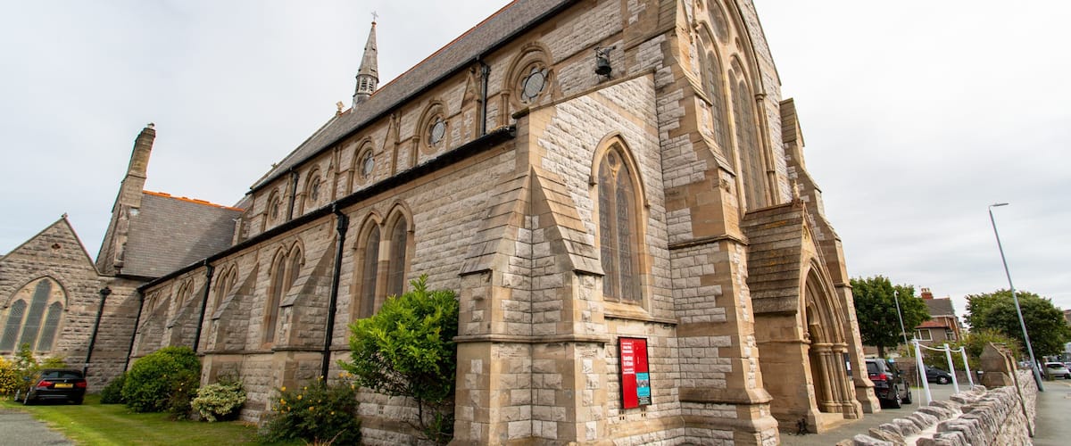 A historic stone church with arched windows and a tall steeple.
