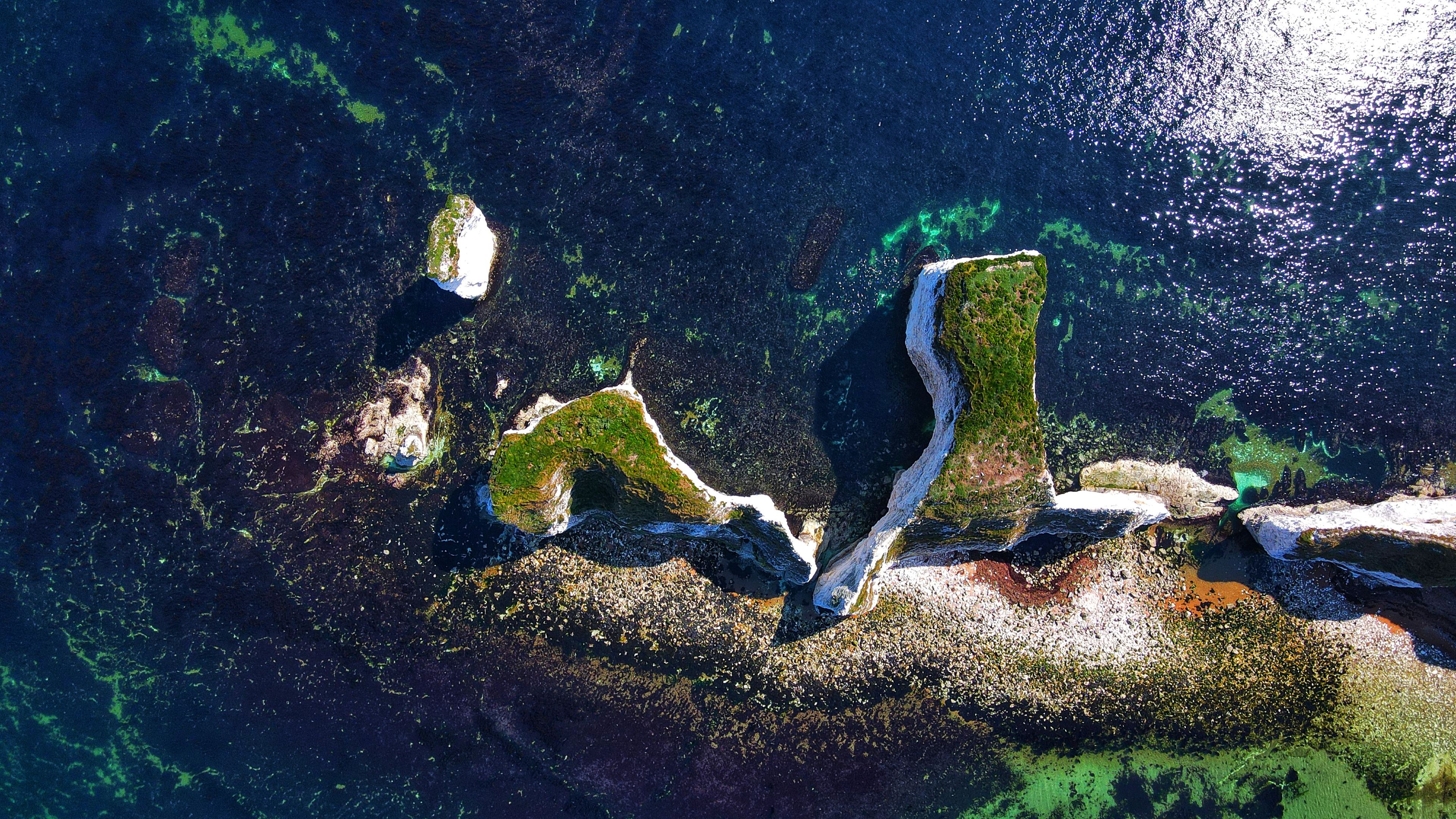 Bird eye view shot of Old Harry Rocks in Isle of Purbeck, Dorset, England with shiny blue water