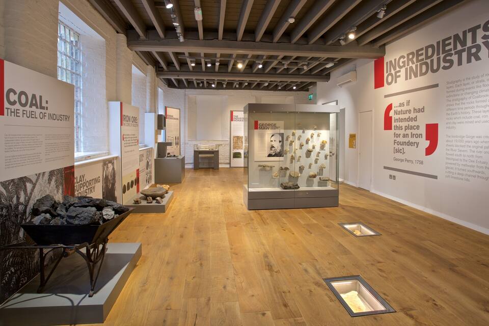 Une exposition de musée en intérieur présentant des collections sur le charbon et le minerai de fer.