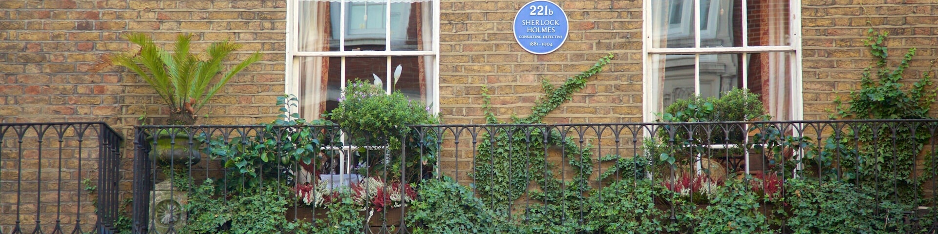 Um edifício de tijolos com uma placa indicando o Museu Sherlock Holmes.