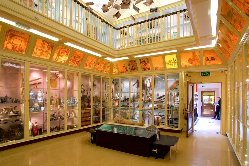 Un musée doté de vitrines exposant des objets historiques et abritant une exposition centrale.