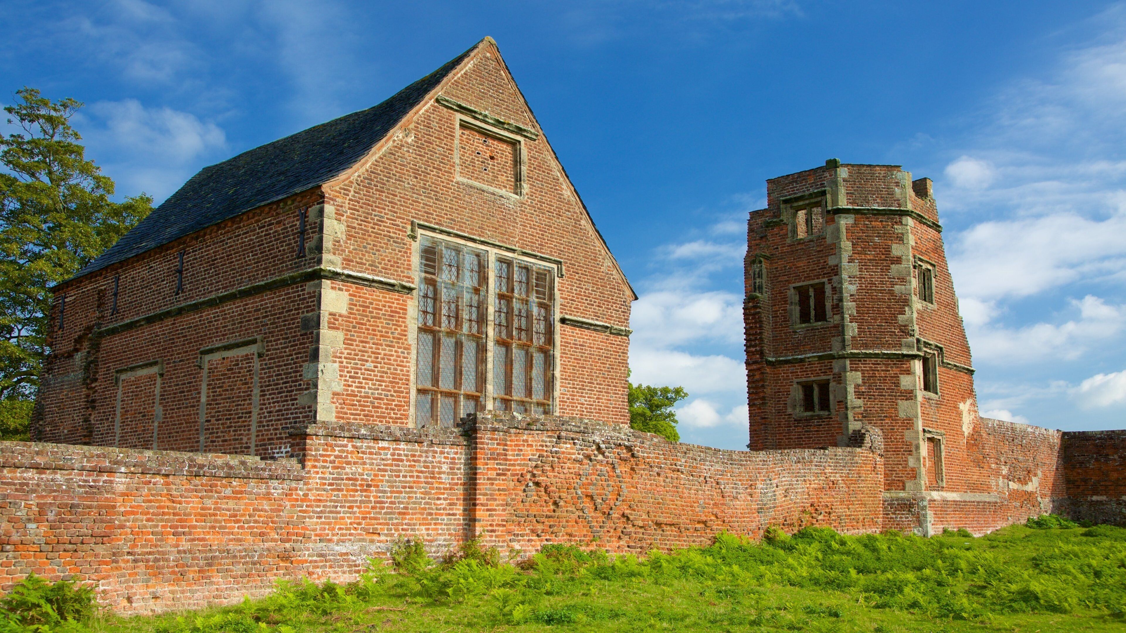 A historic brick building with a tall tower and large windows.