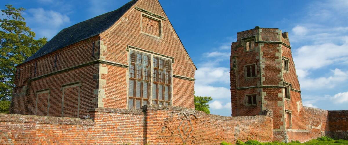 A historic brick building with a tall tower and large windows.