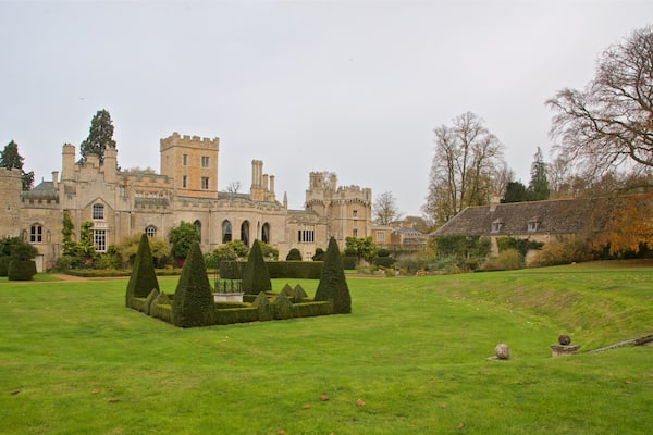 A historic castle with a well-manicured lawn and topiary garden.