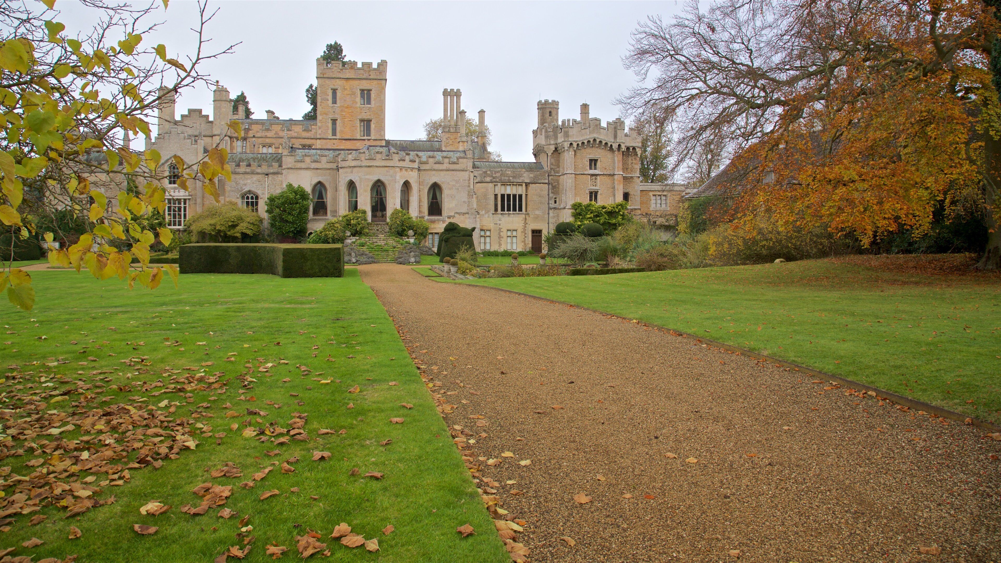A historic building with a symmetrical facade, a gravel path, and autumn foliage.