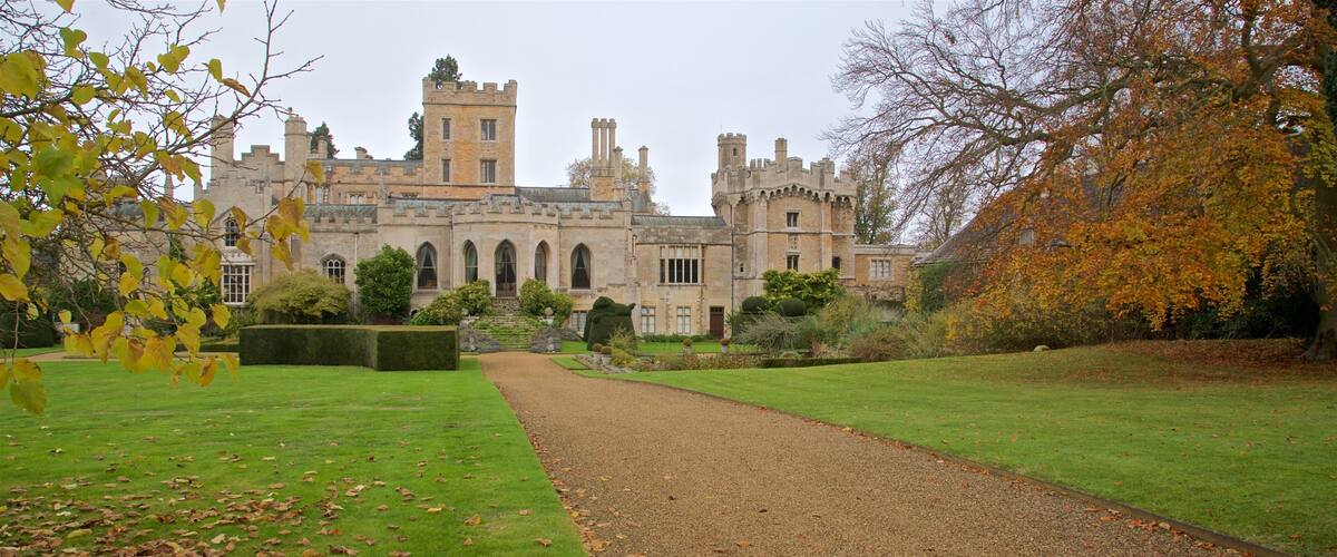 A historic building with a symmetrical facade, a gravel path, and autumn foliage.