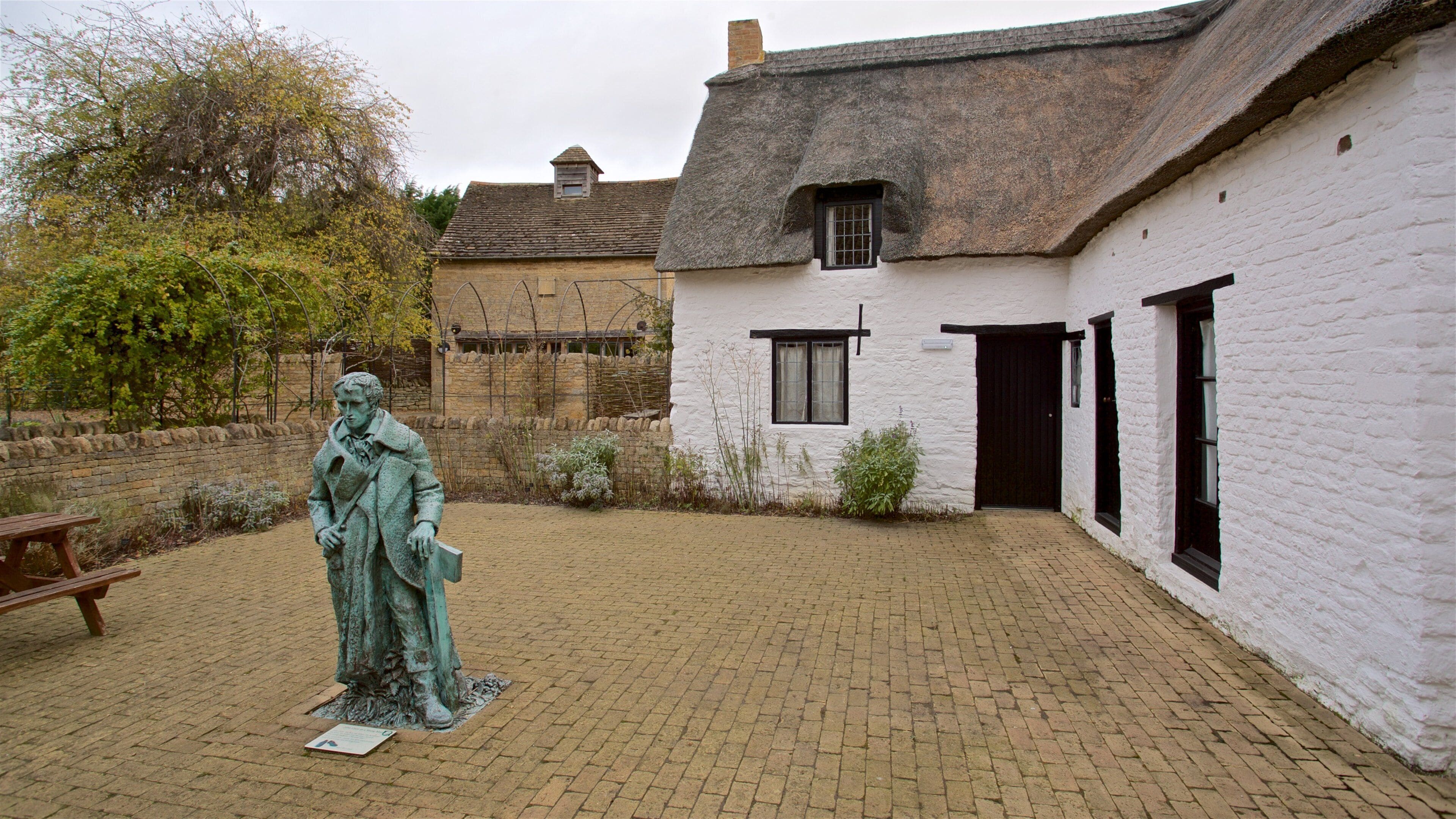 John Clare Cottage das einen Statue oder Skulptur und Haus