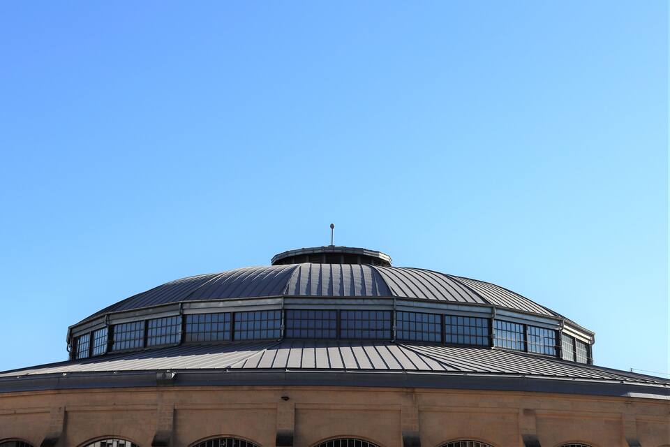 Un ampio edificio a cupola con tetto in metallo e numerose finestre.