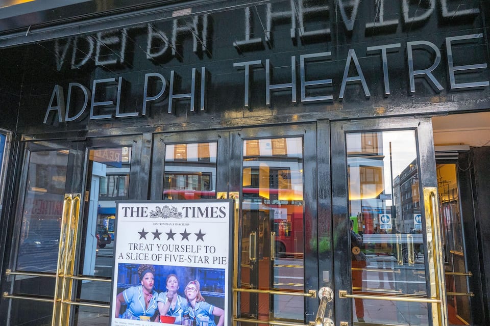 The entrance to Adelphi Theatre with a Times newspaper advertisement.