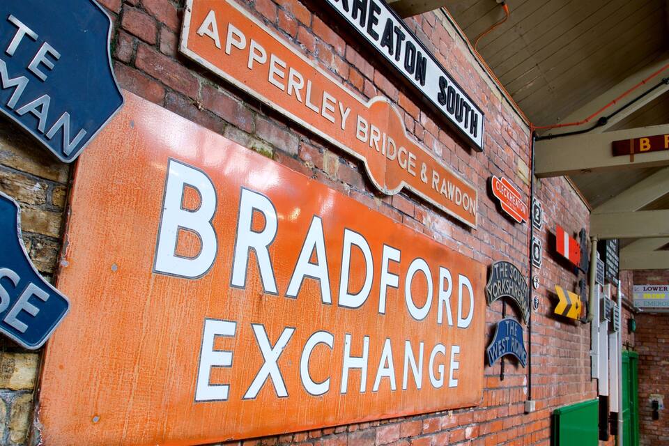 Un mur de briques orné de nombreuses enseignes, dont une grande affiche pour « Bradford Exchange ».