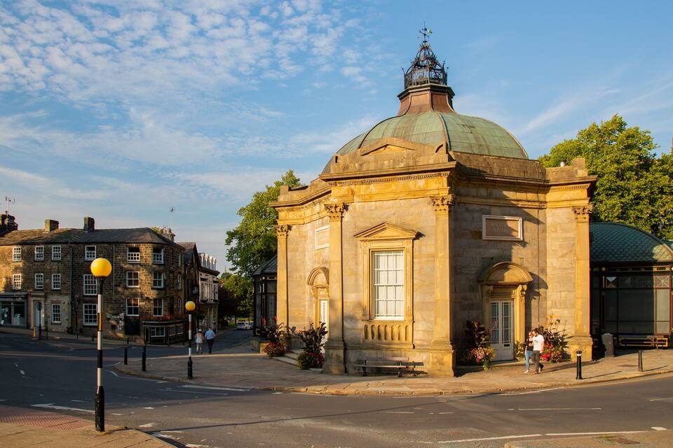 A historic building with a green dome and classical architecture.