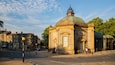 A historic building with a green dome and classical architecture.
