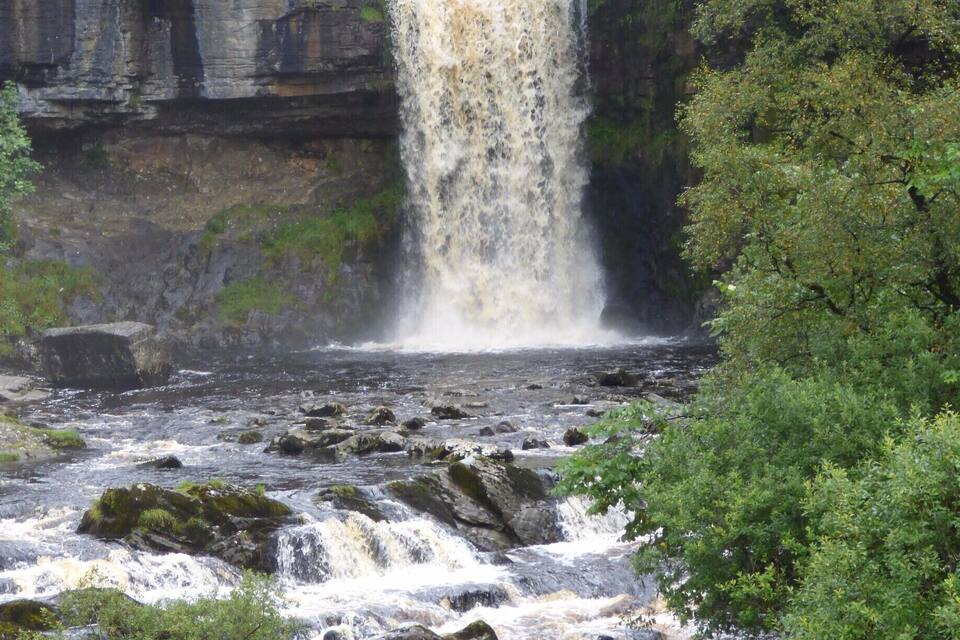 A waterfall cascading over rocks in a forested area.