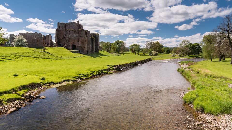 A castle on a hill, a river, and a clear blue sky.