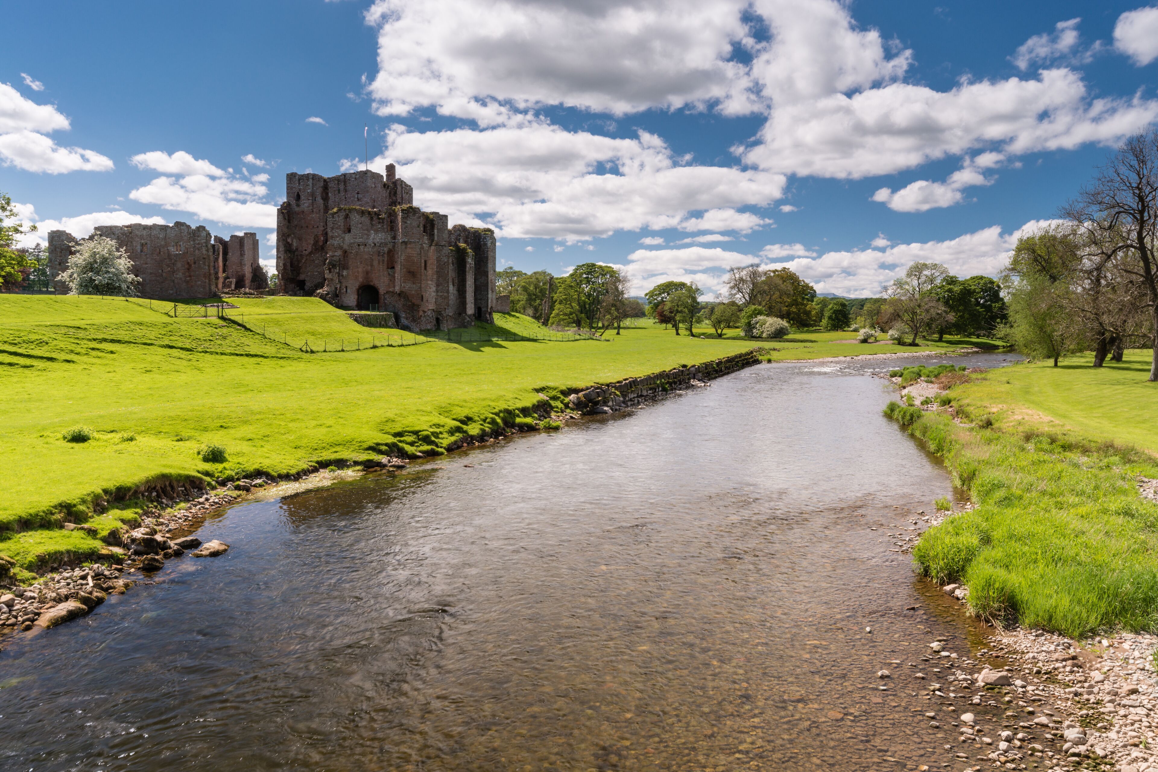 A castle on a hill, a river, and a clear blue sky.
