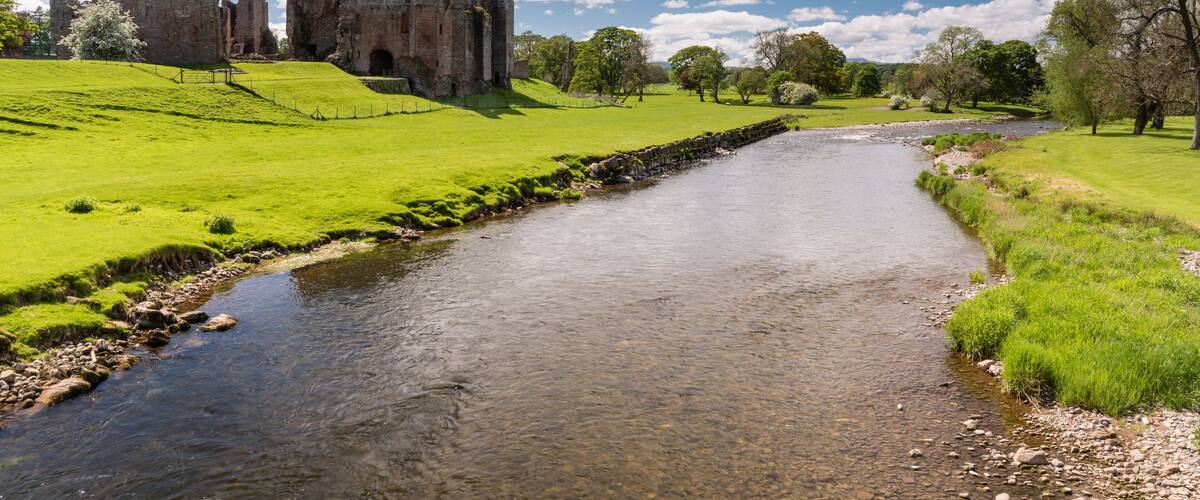 A castle on a hill, a river, and a clear blue sky.