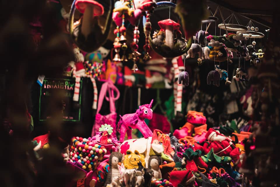 A variety of colorful stuffed animals and toys displayed in a shop.