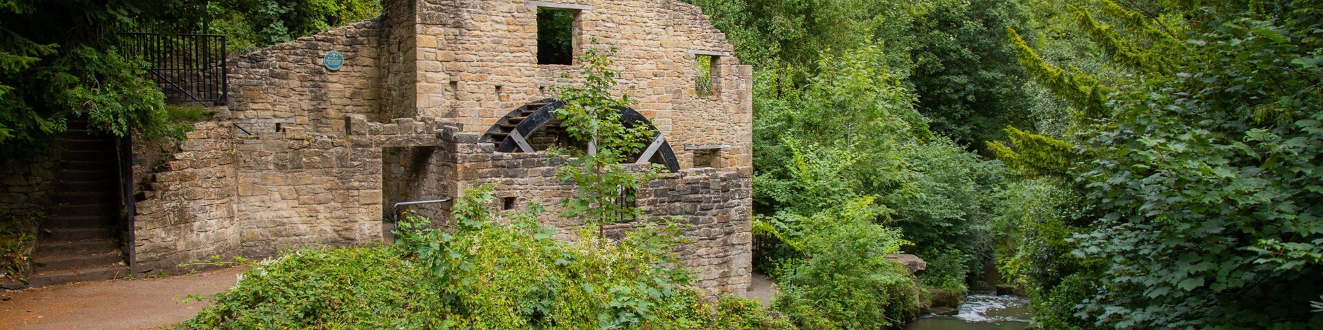 Jesmond Dene Park showing heritage elements, a river or creek and building ruins
