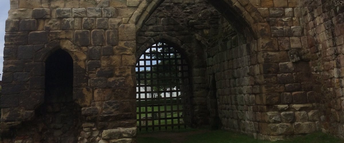 A stone castle ruin with an arched entrance and a small window above it.