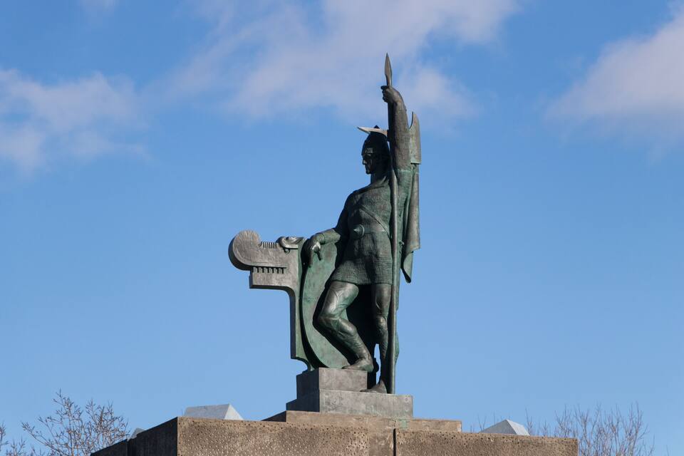 A statue of a warrior holding a spear and shield, standing on a pedestal.