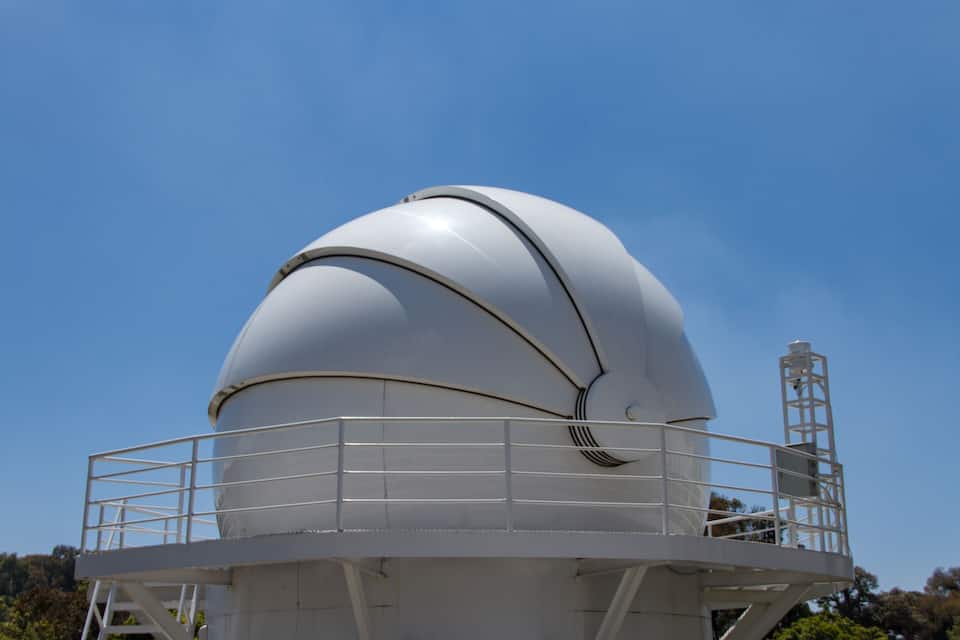 Un osservatorio a forma di cupola, di grandi dimensioni e bianco, con una ringhiera metallica.